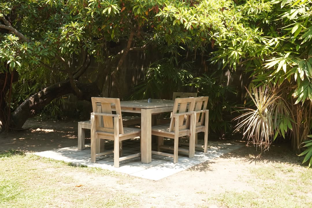 Garden outdoor table set beneath shady trees