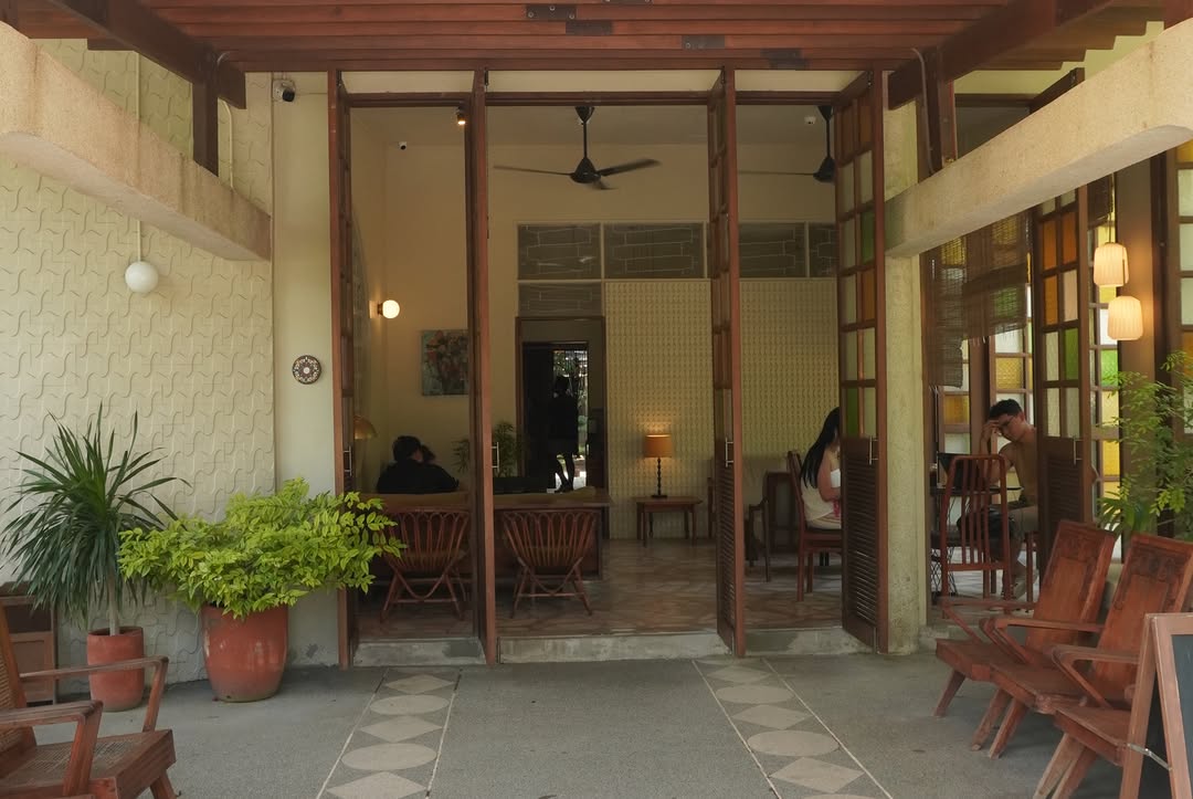 Cafe interior viewed through glass doors with mid-century chairs