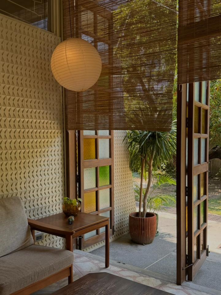 Interior space with bamboo blinds, colorful glass panels and tropical garden view
